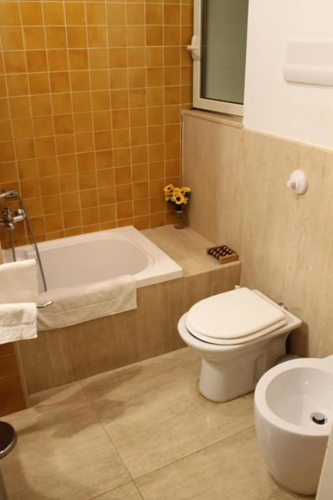 Bagno con vasca, maioliche calde e set di cortesia